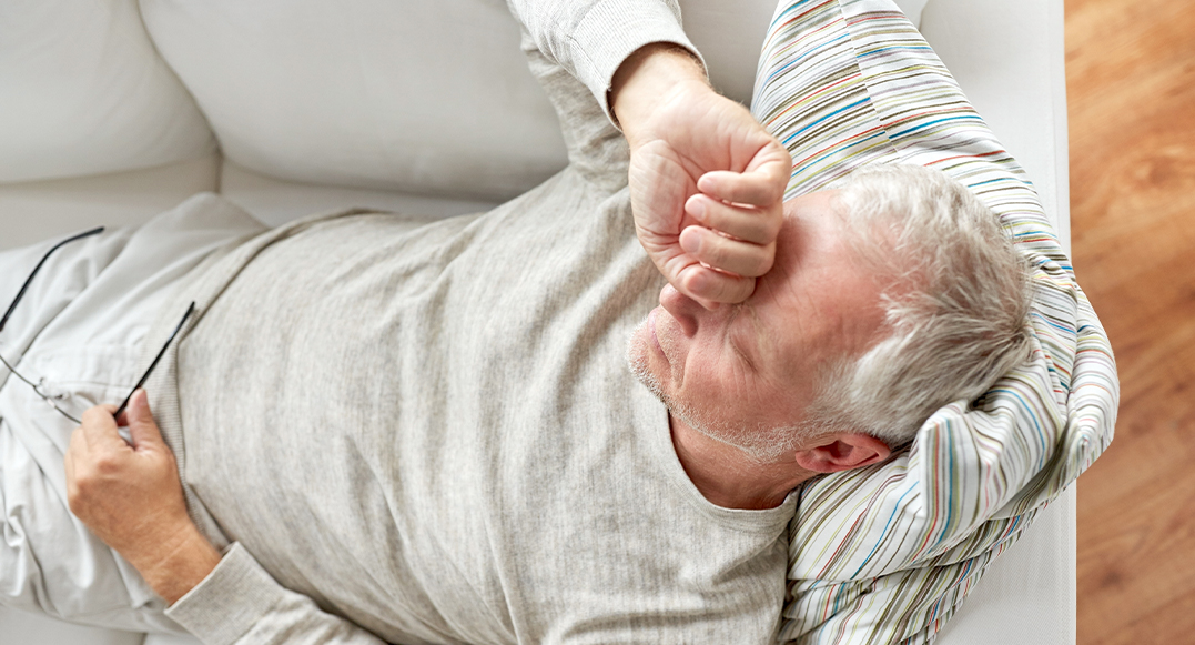 Senior man laying awake in bed before seeing a sleep dentist in North Olmsted